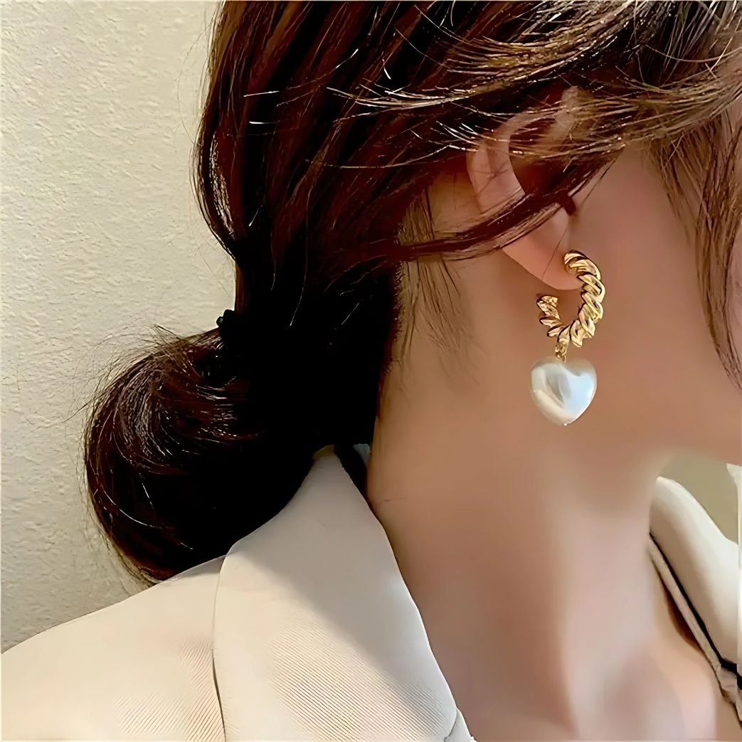 heart pearl earrings worn by woman gold hoop style