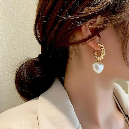 heart pearl earrings worn by woman gold hoop style