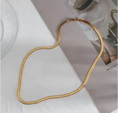 snake chain necklace worn by woman minimal gold jewelry